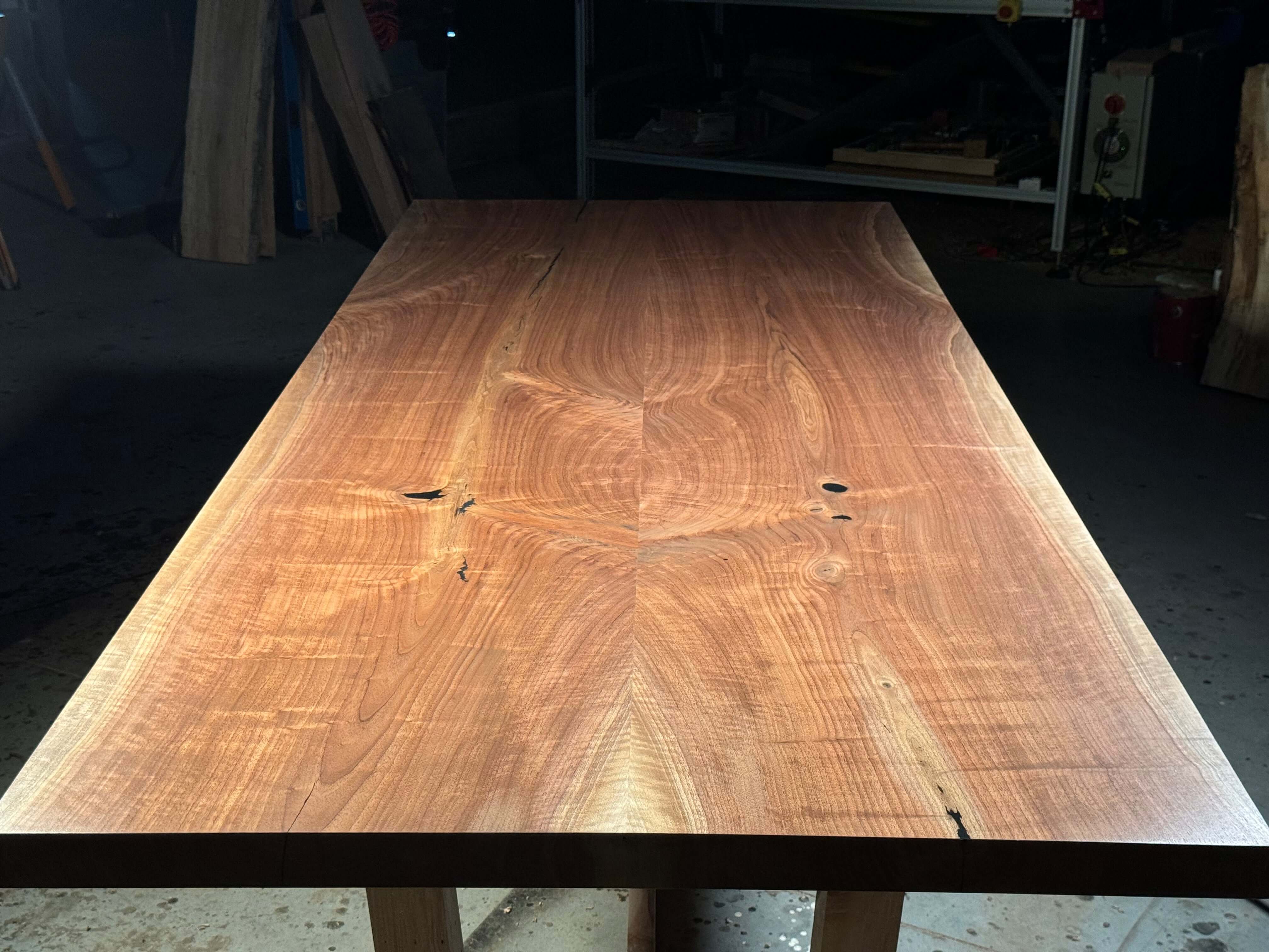 Solid wood dining table with sleek modern design, showcasing smooth textures and rich grain patterns for a sophisticated look.