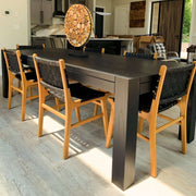 Modern Royal Flush Dining Table with black finish, surrounded by wooden chairs in a contemporary kitchen setting.