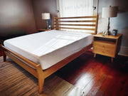 Solid wood Onassis bed frame with mid-century modern design in a stylish bedroom setting.