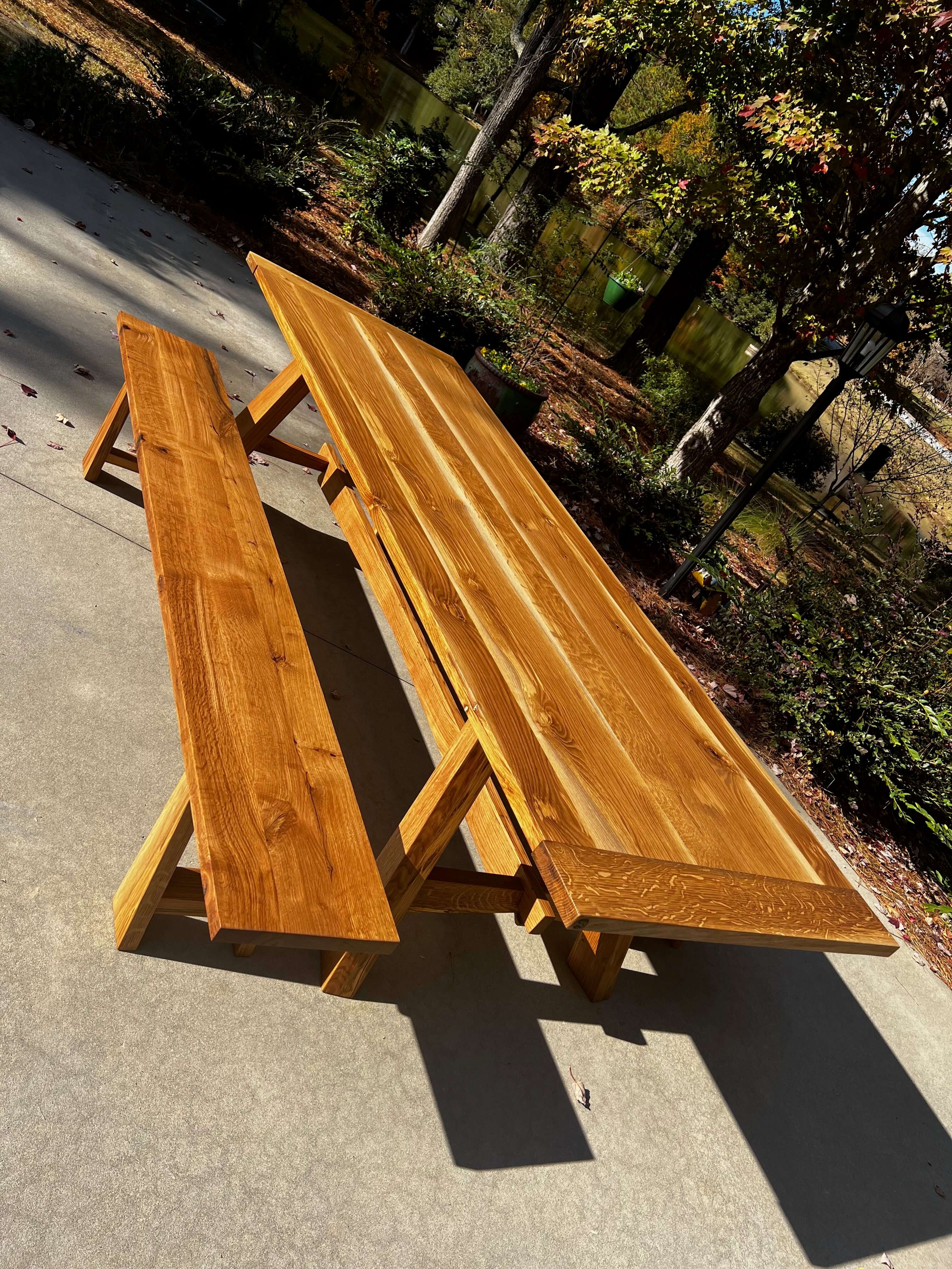 Natural wooden Nikko dining table with matching bench, inspired by Japanese sunlight design, set outdoors on a sunny day.