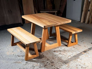 Small kitchen table with unique leg base and matching benches, ideal for breakfast nook or patio dining, modern family style design.