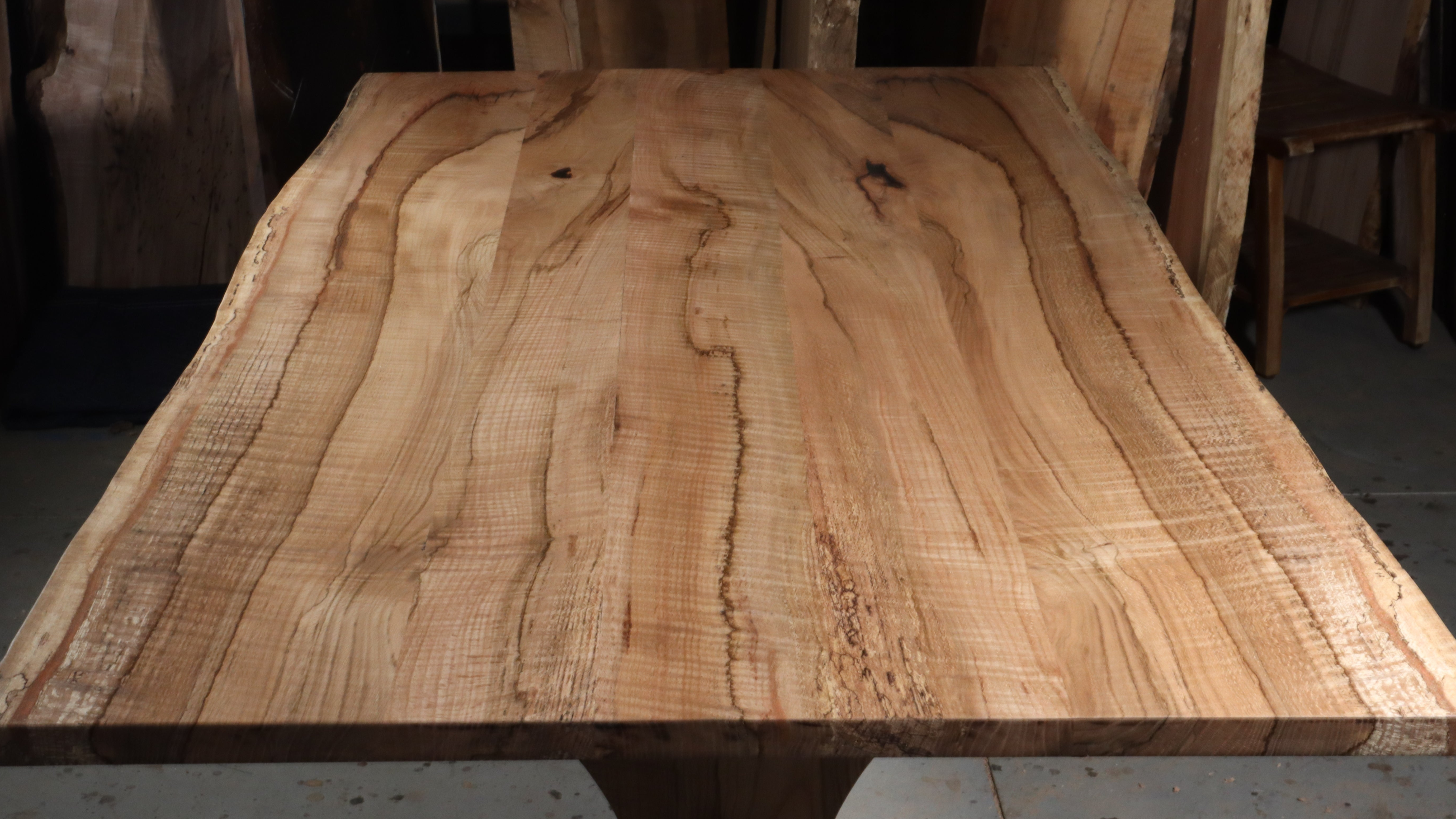 Solid wood Trestle dining table with live edge top, showcasing natural wood grain, ideal for modern or traditional settings.