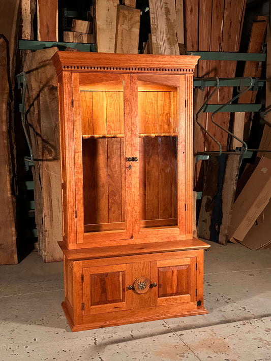 Solid cherry wood gun case with lockable upper and lower cabinets, featuring a secret storage compartment.