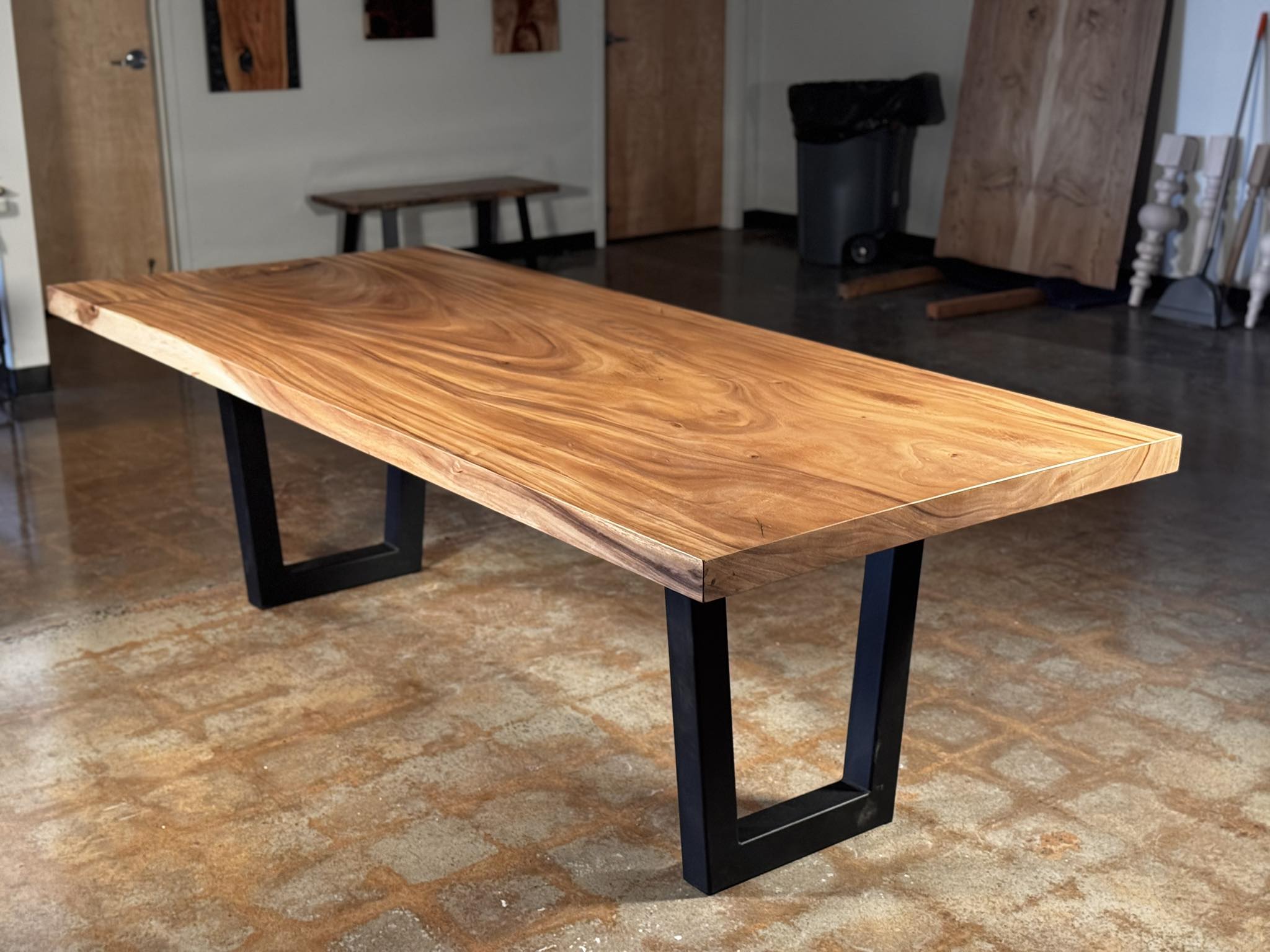 Wooden table with black metal legs on a patterned floor