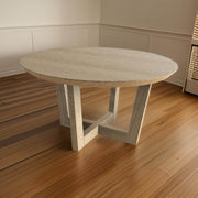 Elegant round dining table with a curved silhouette and detailed craftsmanship on a wooden floor in a modern dining room.