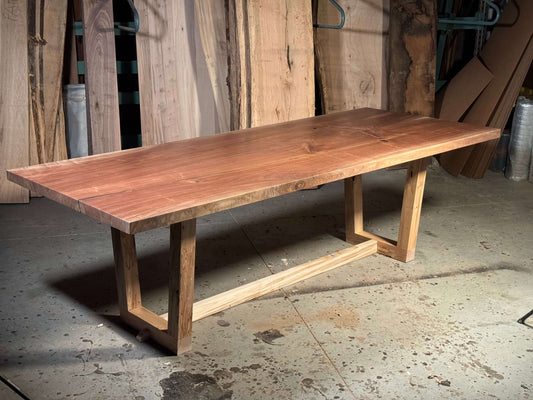 Sleek modern design of The Brooklyn solid wood dining table in a workshop setting, showcasing its simplicity and timeless sophistication.