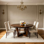 Dining room with wooden table and chairs, fruit plate, and chandelier.