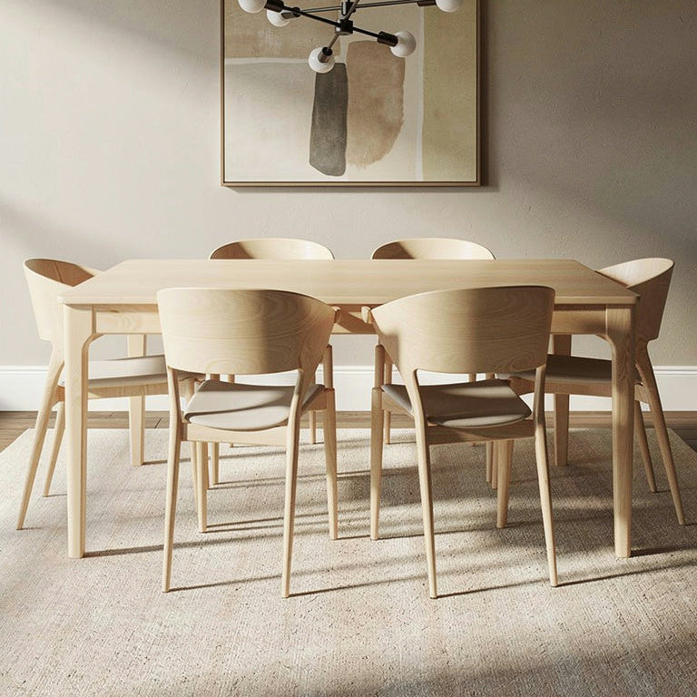 Dining room with wooden table and chairs, abstract painting on the wall, and modern chandelier.