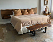 Modern bedroom with a bed, wooden bench, and side table.