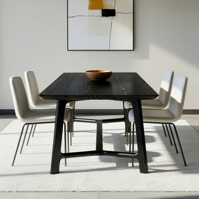 Dining room with a black table and white chairs, abstract art on the wall.