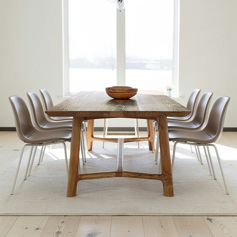 Dining area with a wooden table and modern chairs in a bright room.
